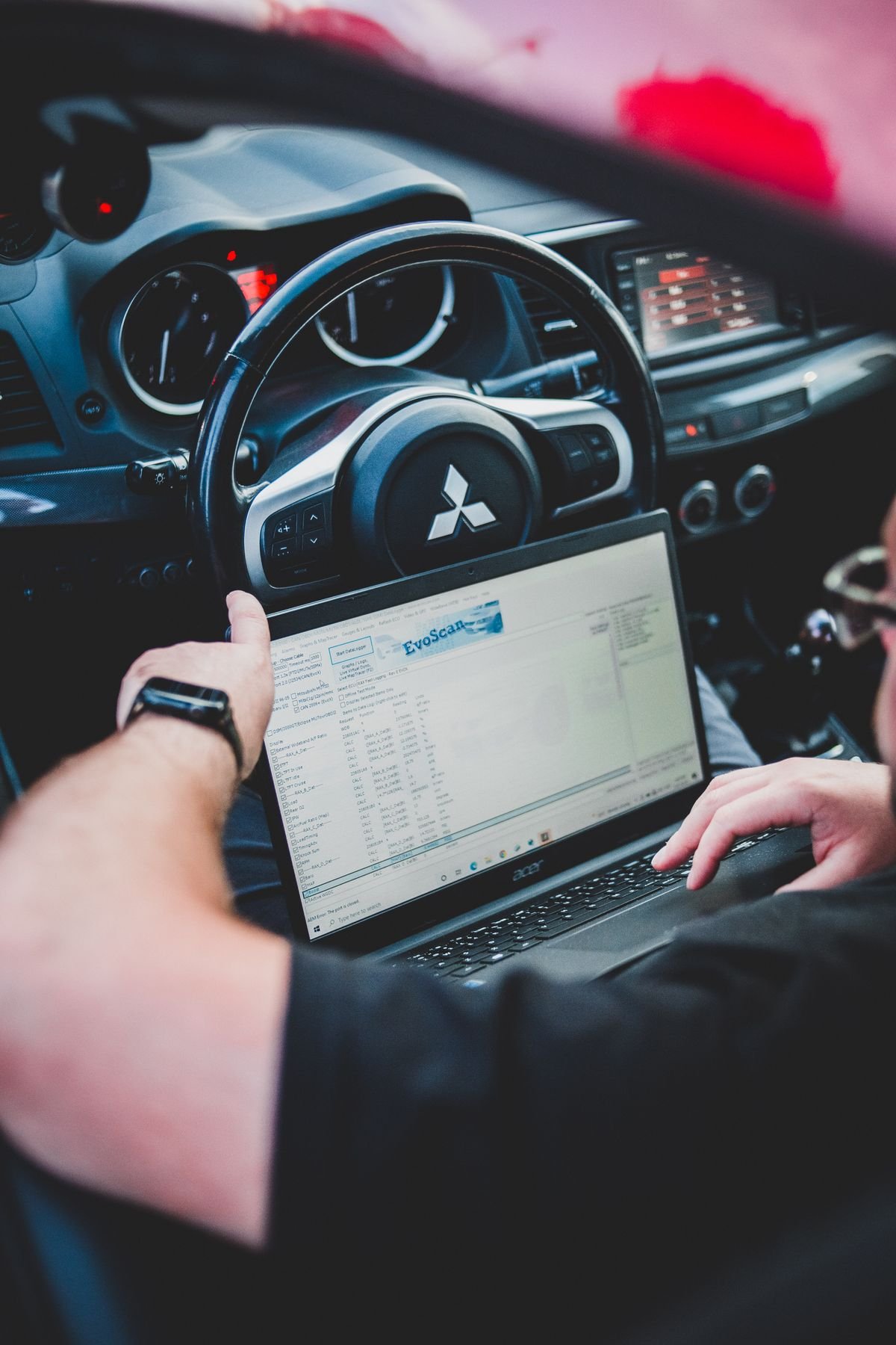 Technician running ADAS recalibration diagnostics after windshield replacement