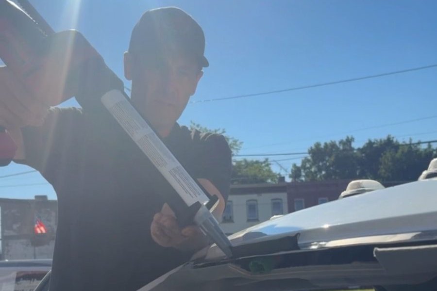 Newburgh Auto Glass technicians lifting and setting a windshield on a truck